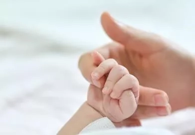 Mother holding the hands of her baby