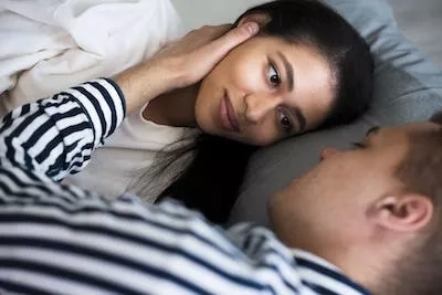 Couple lying down on their bed