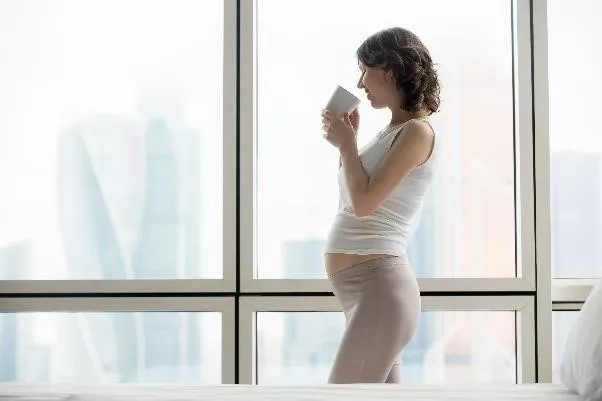 pregnant woman drinking from a glass of water