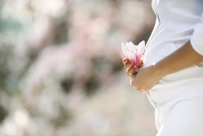 Pregnant mom holding a flower against her belly
