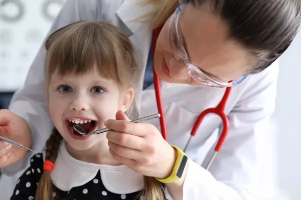 Young child getting her teeth checked during a dental visit.