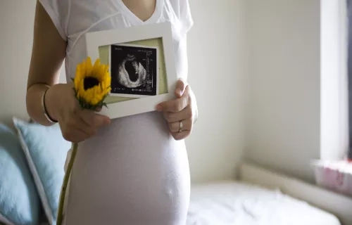 Pregnant mother holding up an ultrasound scan